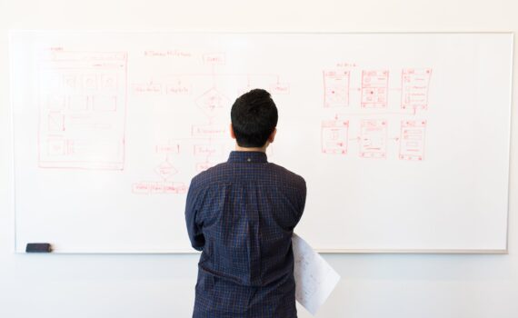 man standing infront of white board